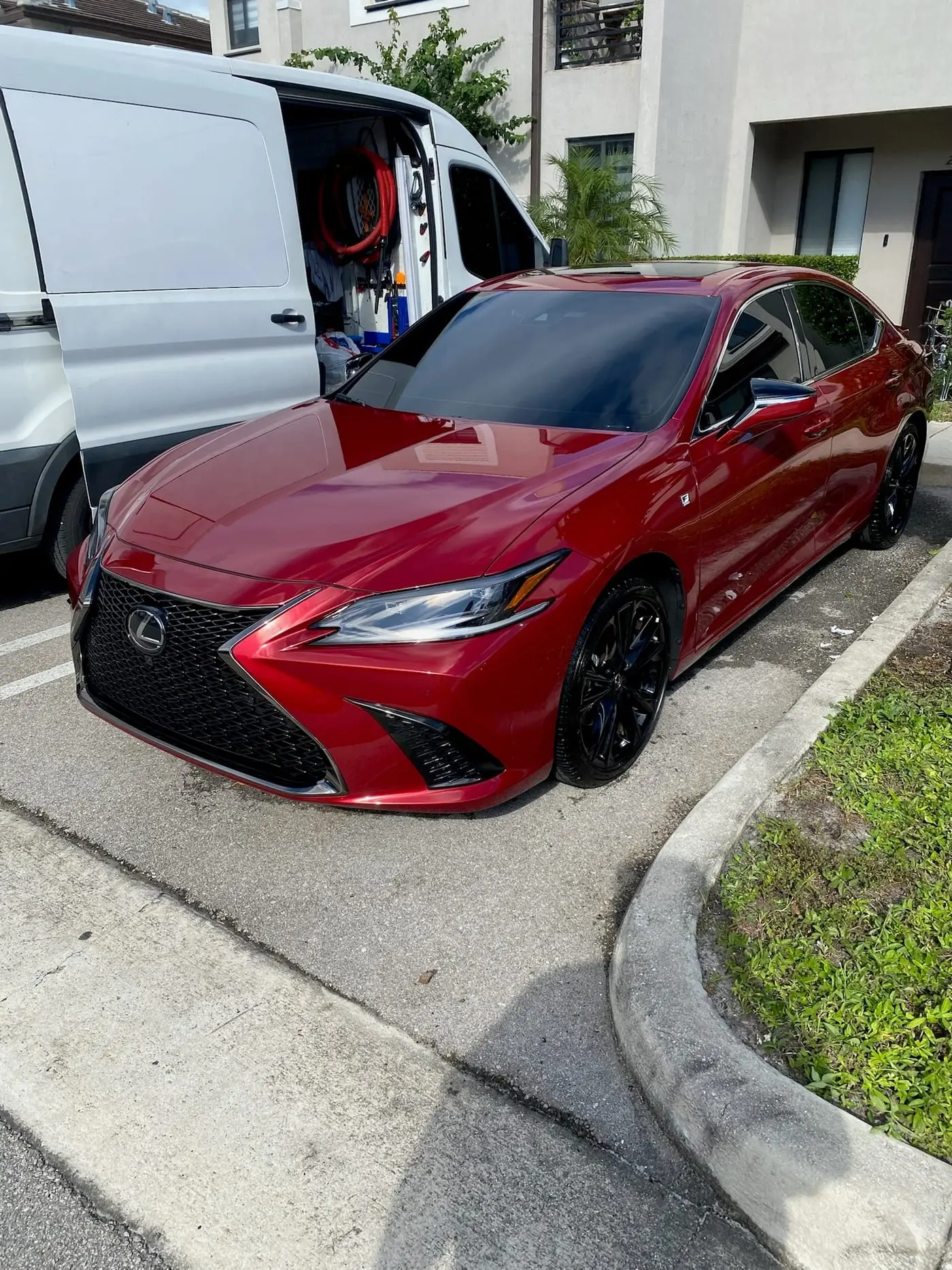 A red Lexus ES freshly washed beside the Scrub N Sudz van