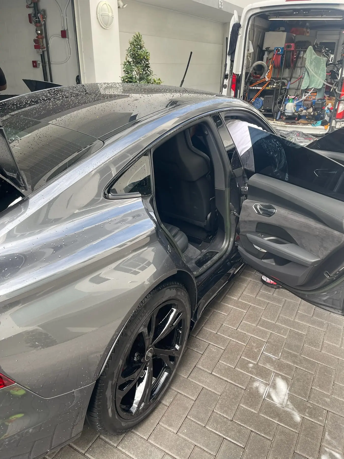A detailer working through an Audi interior on the customer's driveway